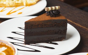 A piece of mouth-watering chocolate cake on a white plate