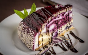 Кусок черничного пирога с джемом на белой тарелке с вилкой