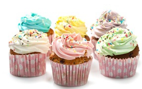 Аппетитные капкейки с кремом на белом фоне