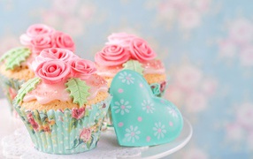 Appetizing capkakes with pink roses made of mastic and heart