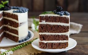 Appetizing coffee cake with cream and berries of blueberries and blackberries