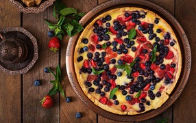 Appetizing pie with berries on a wooden table