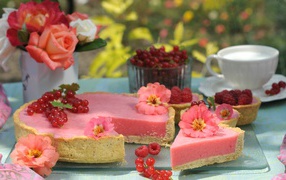 Appetizing pie with raspberries and red currant on a table with flowers