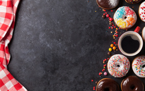 Appetizing sweet donuts with coffee on a gray background