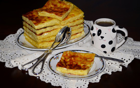 Аппетитный сладкий пирог с чашкой чая на столе