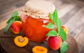 Абрикосовое варенье в банке на столе с абрикосами