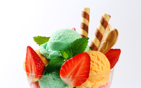 Шарики разноцветного мороженого с клубникой и трубочками