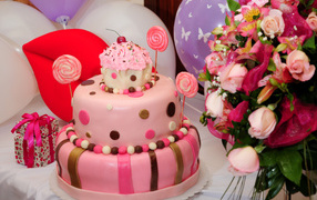 Beautiful pink birthday cake with bouquet of flowers