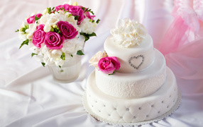Beautiful wedding cake with a bouquet of flowers on a white background