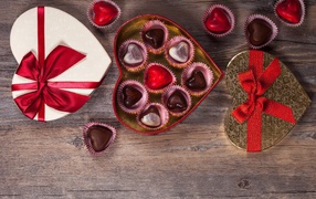 Коробки с шоколадными конфетами в форме сердца на столе 