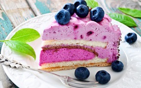Cake with blueberry mousse and fresh blueberries on a white plate