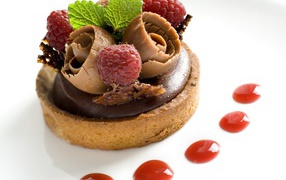 Пирожное с шоколадом и ягодами малины на белом фоне