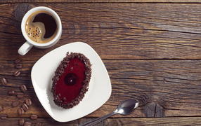 Cake with chocolate on a wooden table with a cup of coffee