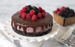 Cake with chocolate on the table with berries of blueberries and raspberries