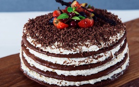 Chocolate cake with cream and grated chocolate decorated with berries