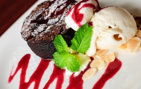 Шоколадное пирожное с мороженым и джемом на тарелке