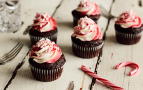 Chocolate cupcakes with cream on a wooden table