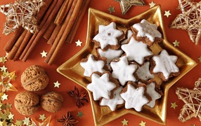 Печенье с глазурью на столе с орехами, корицей и бадьяном