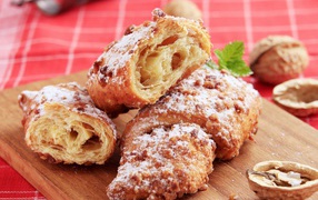 Круассаны с орехом и сахарной пудрой на разделочной доске