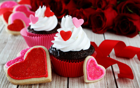 Капкейки с кремом и печенье в форме сердечек на столе