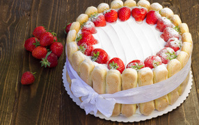 Delicious cake with strawberries and cookies tied with a bow