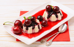 Десерт с желе и ягодами черешни на тарелке с сиропом