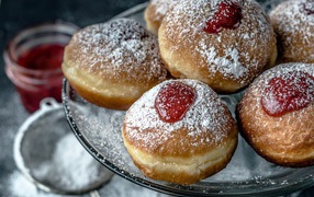 Donuts with jam and powdered sugar on a dish