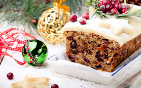 Праздничный новогодний кекс с сухофруктами и игрушками на столе