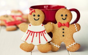 Festive cookies boy and girl with a cup on the table