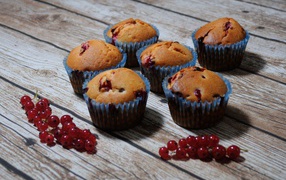 Свежие кексы с красной смородиной на деревянном столе 