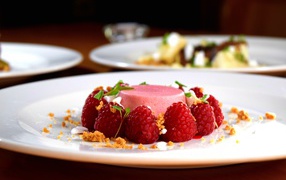 Фруктовое суфле на большой белой тарелке с ягодами малины