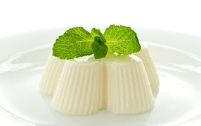 Молочное желе с мятой на белой тарелке 