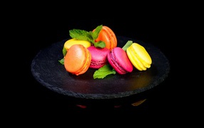 Разноцветный десерт макарон на черном фоне