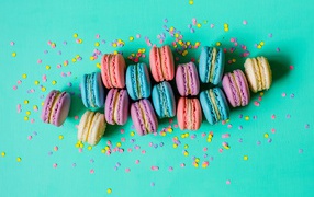 Multicolored macaroon dessert on a blue background with confetti