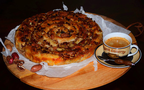 Pie with nuts on a table with a cup of coffee
