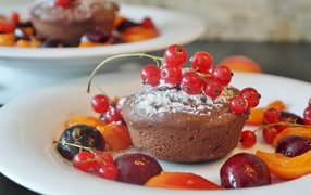 Кексы с красной смородиной на тарелке с ягодами 