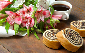 Roll with poppy on a table with alstroemeria flowers and a cup of coffee