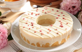 Круглый кекс с глазурью на белом блюде 