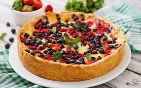 Сладкий пирог с черникой и клубникой на белом блюде