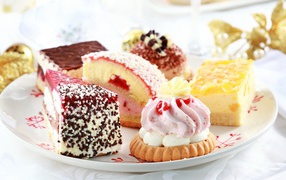 Сладкие вкусные разные пирожные на тарелке