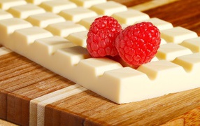 Sweet white chocolate with raspberry berries on the table