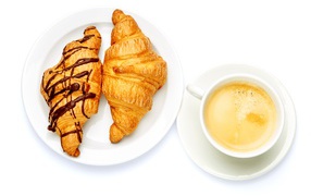 Two croissants with a cup of coffee on a white background