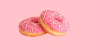 Два пончика с глазурью на розовом фоне