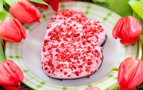 Два печенья в форме сердца на тарелке с тюльпанами 