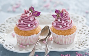 Два вкусных капкейка с кремом на тарелке