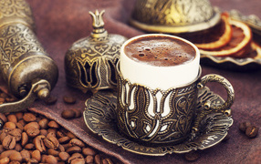 Красивая дизайнерская чашка кофе на столе с зернами