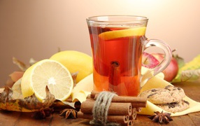 A cup of tea with lemon and cinnamon on a table with lemons