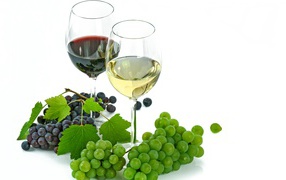 A glass of white and red wine on a white background with grapes