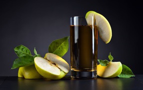 Яблочный сок в стакане на столе со свежими яблоками на сером фоне