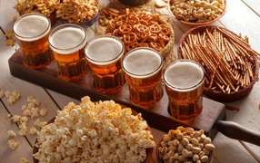 Beer with nuts, pistachios, popcorn and cookies on the table